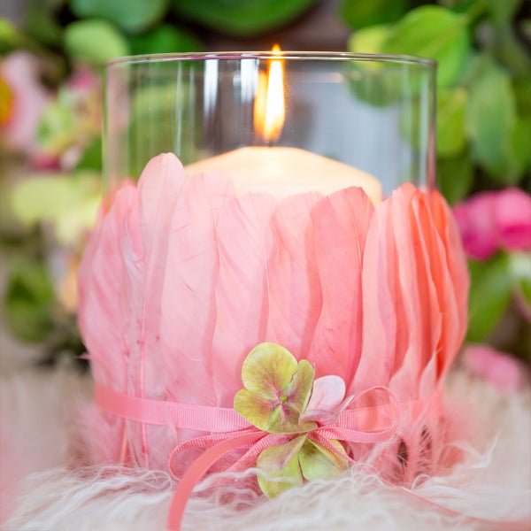 Dekoratives Windlichtglas mit Federn und Kerze