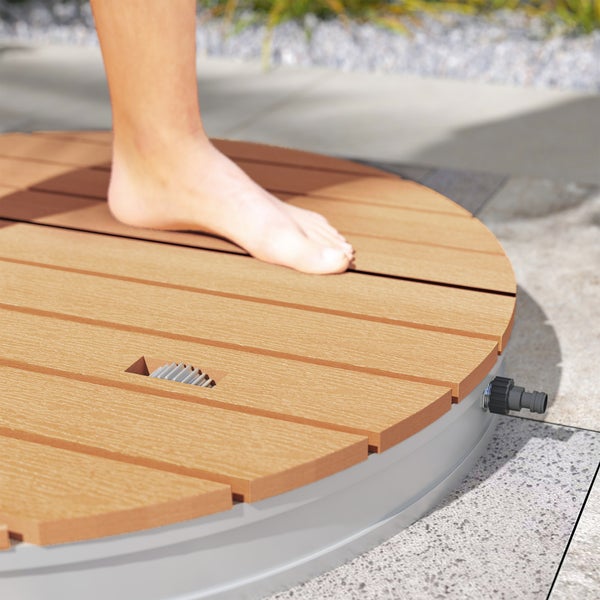 Runde Bodendusche für den Garten mit Holzoptik-Lamellen und Schlauchanschluss, wird durch Auftreten mit dem Fuß aktiviert.