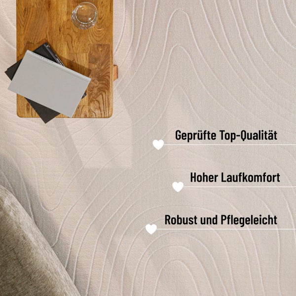 Texturierter Teppich mit Wellenmuster neben einem Holztisch und Sofa, bietet geprüfte Qualität, hohen Laufkomfort und ist robust sowie pflegeleicht.