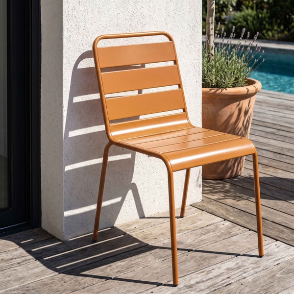 Moderner Gartenstuhl aus Metall mit Querlatten auf einer sonnigen Holzterrasse neben einem Pool.