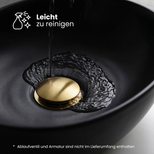 Schwarzes Aufsatzwaschbecken mit goldfarbenem Ablaufventil und fließendem Wasser, Symbol für einfache Reinigung.