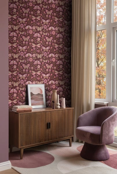 Tapete mit Schmetterlings- und Libellenmuster in einem Wohnzimmer mit Sideboard aus Holz, lilafarbenem Sessel und hellem Vorhang.