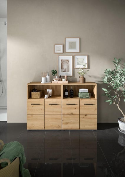 Moderner Badezimmer-Seitenschrank in Holzoptik mit vier Schubladen, offenen Ablagefächern und schwarzen Griffen, stilvoll dekoriert.