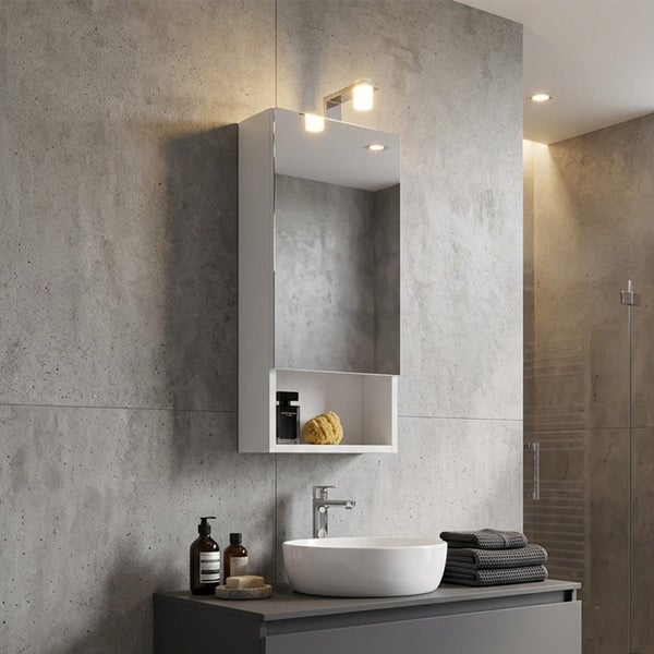 Moderner weißer Spiegelschrank mit LED-Beleuchtung und offenem Fach über einem Waschbecken in einem Badezimmer mit Betonwand.