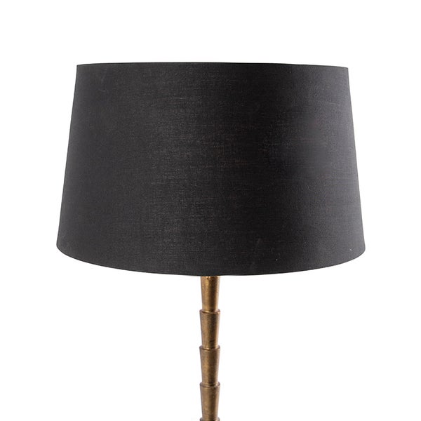 Stehlampe mit schwarzem Lampenschirm und goldenem Ständer