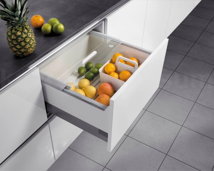 Geöffnete Küchenschublade mit Obst-Organisationssystem inklusive Deckel und Behälter, gefüllt mit Zitrusfrüchten.