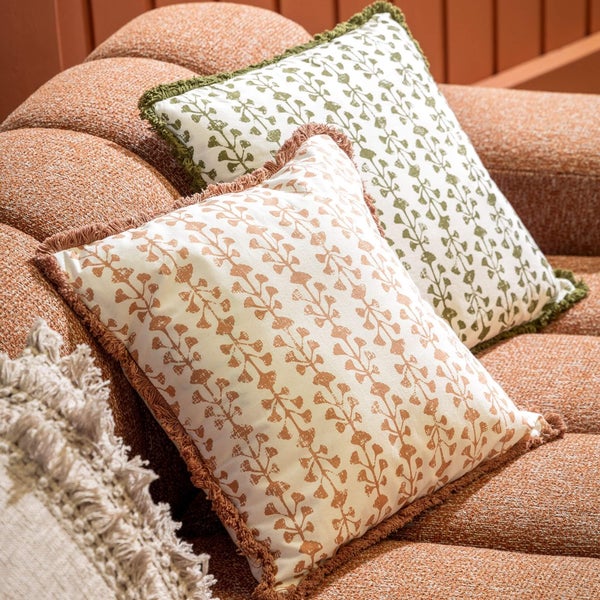 Dekorative Kissen mit Pflanzenmuster und Fransen auf einem Sofa