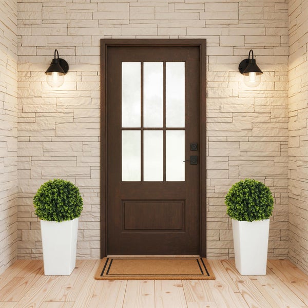 Eingangsbereich mit Holztür, Wandleuchten und Topfpflanzen