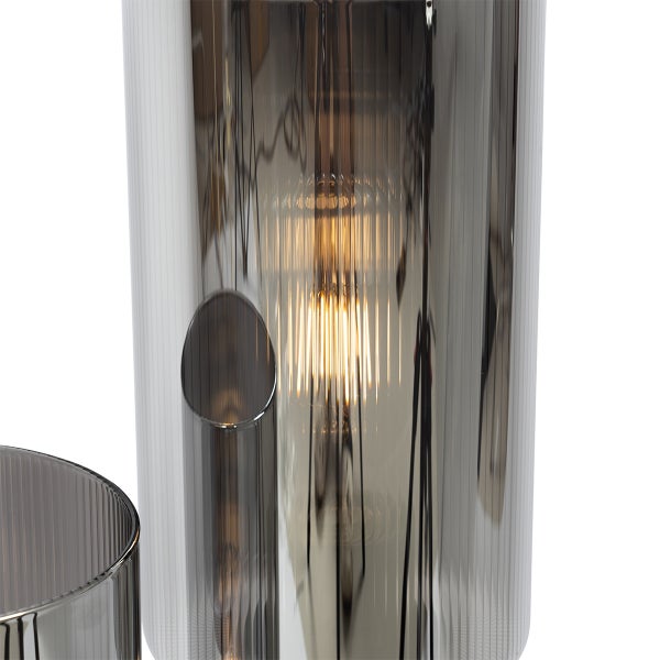 Nahaufnahme einer Tischleuchte aus Rauchglas mit eingeschalteter Glühbirne