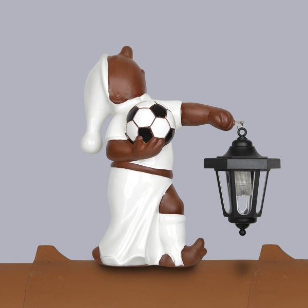 Dekorative Dachfigur auf einem Firstziegel mit einem Fußball und einer Solar-Laterne.