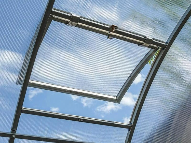 Geöffnetes Dachfenster mit Rahmen aus Metall in einem Gewächshaus mit Hohlkammerplatten
