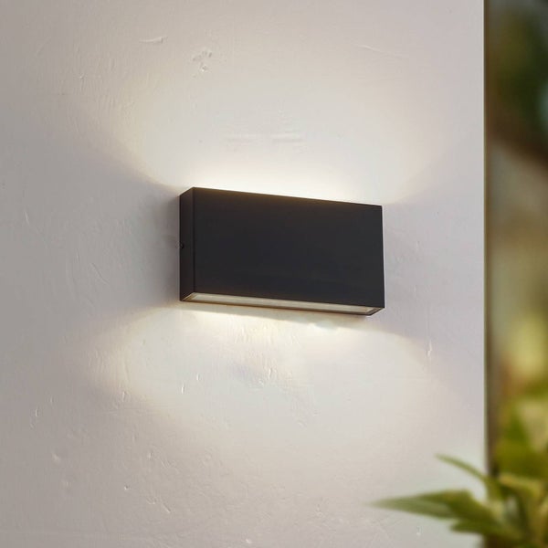 Moderne rechteckige Außenwandleuchte in Schwarz mit Lichtaustritt nach oben und unten an einer Wand.