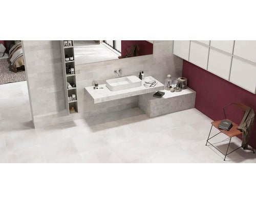Modernes Badezimmer mit Waschtisch, Waschbecken, Spiegel und Fliesen in Steinoptik, großzügig und hell gestaltet.