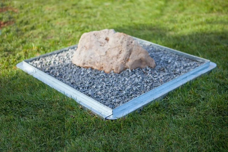 Stein in einem Beet auf Rasen