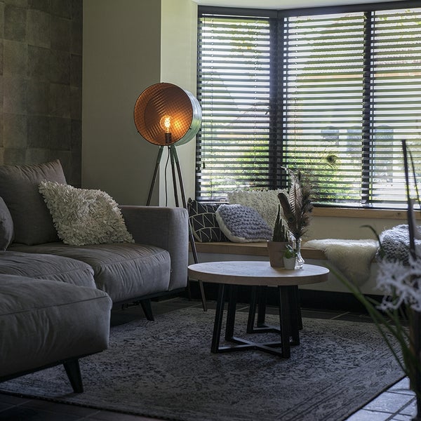 Wohnzimmer mit Sofa, Stehlampe und Fenster mit Jalousien