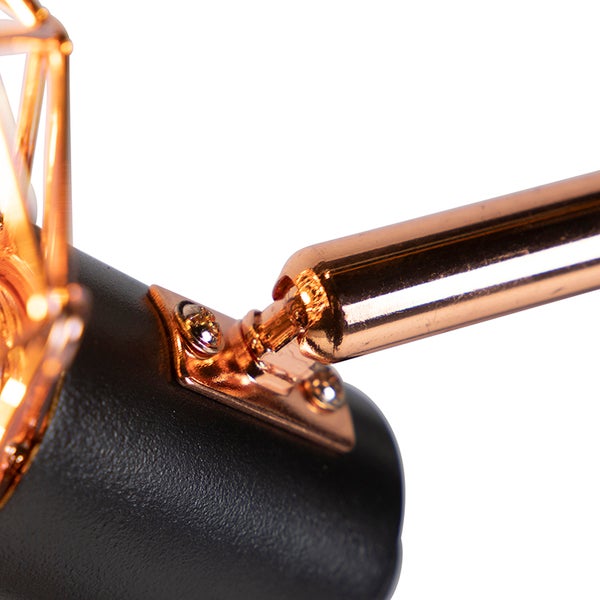 Detailaufnahme einer Lampe mit Metallelementen und schwarzem Lampenfuß.