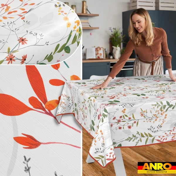 Eine Frau legt eine floral gemusterte Tischdecke auf einen Tisch in einer hellen Küche. Detailansichten zeigen das Blumenmuster. Anro Logo.