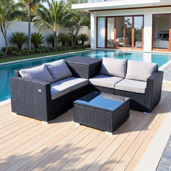 Gartenmöbel-Set aus Polyrattan mit Tisch und grauen Kissen neben einem Pool