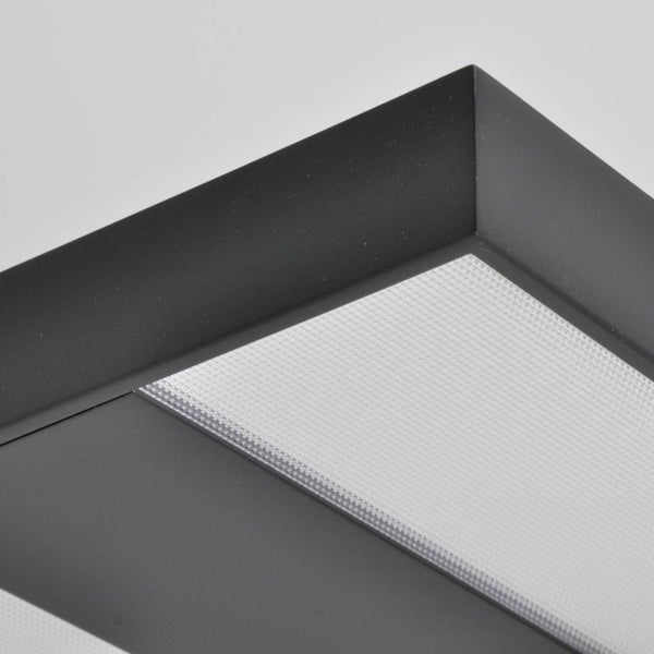 Nahaufnahme der Ecke einer Deckenleuchte mit dunklem Rahmen und strukturiertem Diffusor.