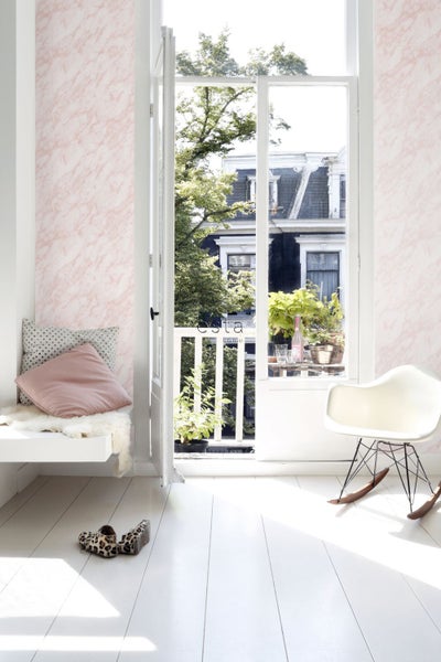 Heller Raum mit Marmortapete, Balkontür und Sitzgelegenheit