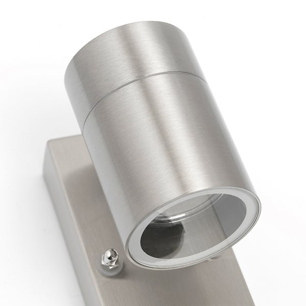 Zylindrische Wandleuchte aus gebürstetem Metall mit verstellbarem Spotkopf.