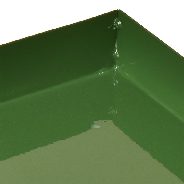 Detailansicht einer grünen Pflanzschale aus Metall mit Wasserresten