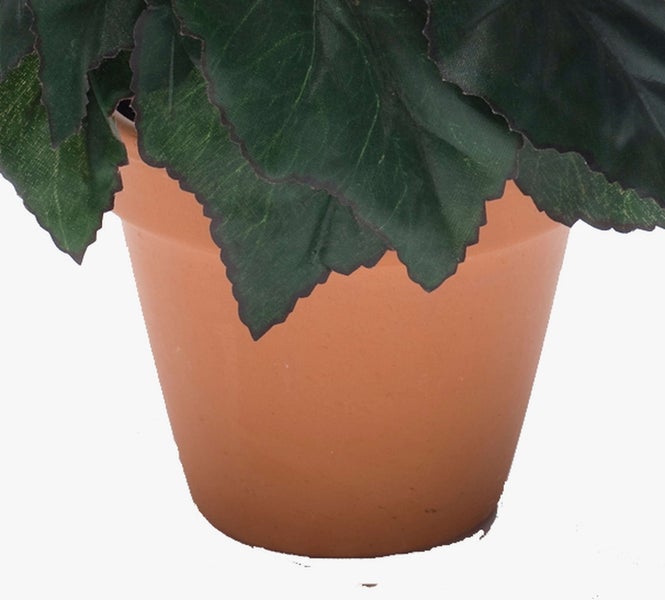 Künstliche Pflanze mit gezackten grünen Blättern in einem Terrakotta-Topf.