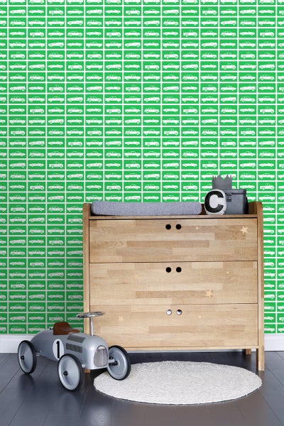 Helles Kinderzimmer mit Wickelkommode, Spielzeugauto und grüner Tapete mit Automobilmuster