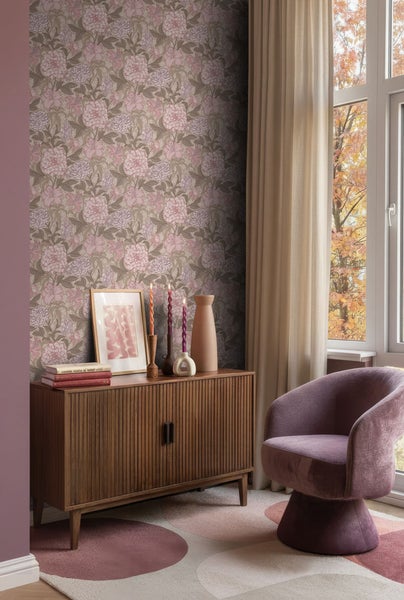 Wohnzimmer mit blumiger Tapete, Holzkommode, Sessel und Fenster