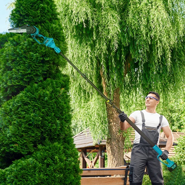 Mann schneidet Baum mit einer Akku-Hochentaster im Garten
