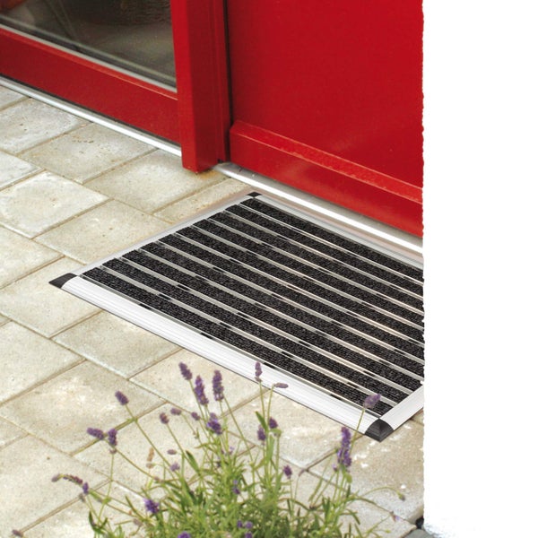 Fußmatte mit Aluminiumprofilen vor einer roten Tür