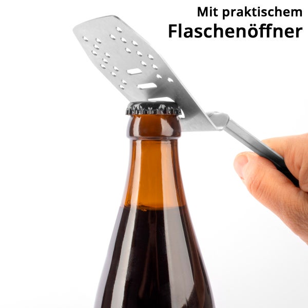 Grillspatel aus Edelstahl mit integriertem Flaschenöffner beim Öffnen einer Getränkeflasche.