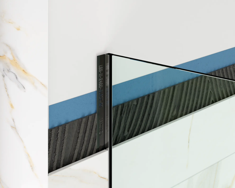 Detailansicht eines schwarzen Metallprofils für Fliesen in einer Wandinstallation mit Abdichtung und Kleber.