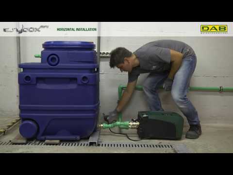 Installateur montiert Hebeanlage in einem Installationsraum. DAB Logo