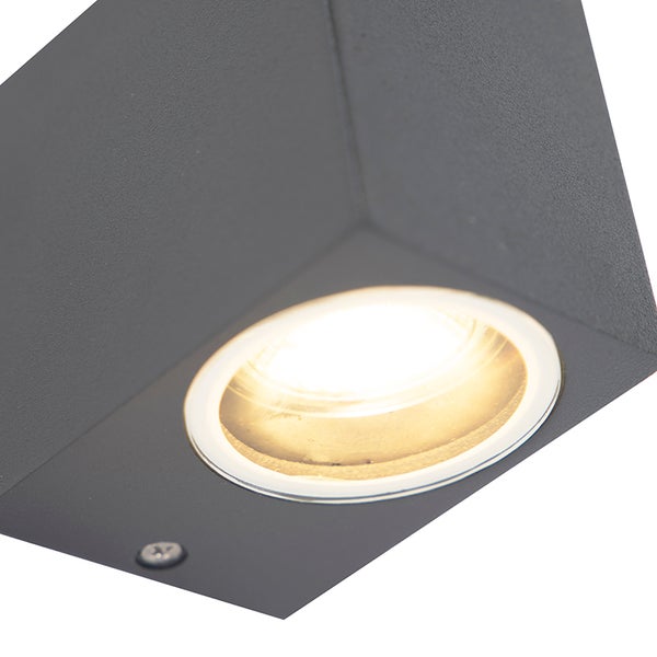 Nahaufnahme einer eckigen, dunkelgrauen LED Wandleuchte mit warmweißem Lichtstrahl.