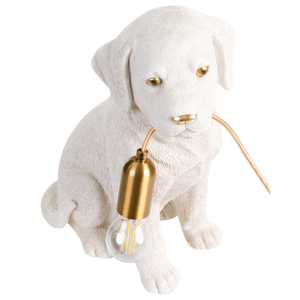 Tischleuchte in Form eines sitzenden weißen Hundes mit goldfarbenem Kabel im Maul und Filamentleuchtmittel.