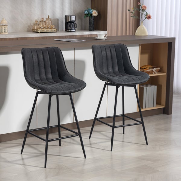 Zwei gepolsterte Barhocker mit dunklen Bezügen und schwarzen Metallbeinen in einer modernen Küche an einem Tresen.
