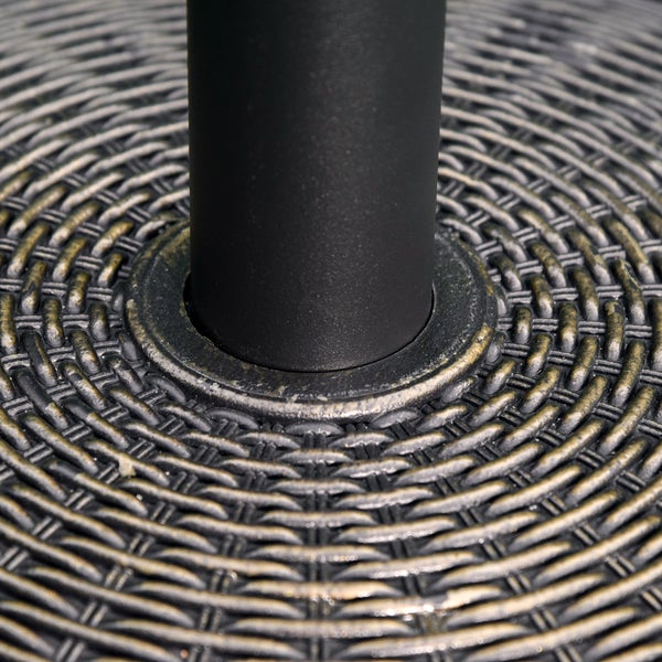 Nahaufnahme eines Gartentischs mit runder Tischplatte in Rattan-Optik und einem zentralen Metallrohr.