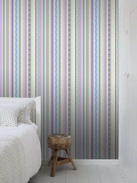 Schlafzimmer mit gestreifter Tapete und Holzhocker