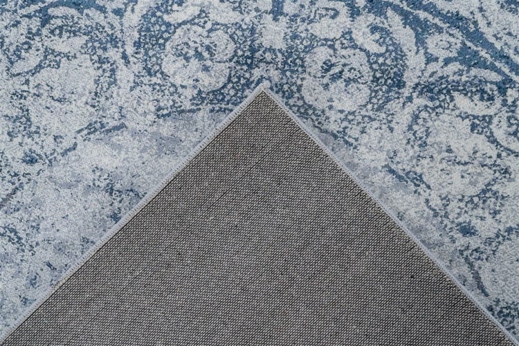 Teppich mit floralem Vintage-Muster, Detail einer umgeschlagenen Ecke mit strukturierter Rückseite.