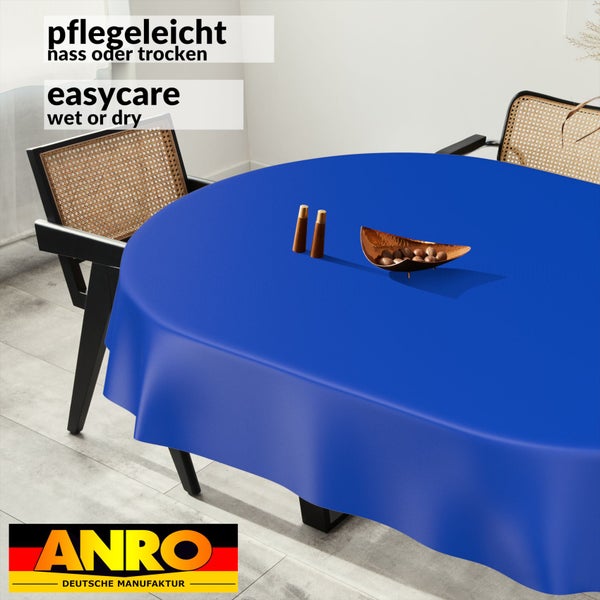 Runde blaue Tischdecke auf einem Esstisch in einem hellen Raum, pflegeleicht nass oder trocken zu reinigen, ANRO Logo.