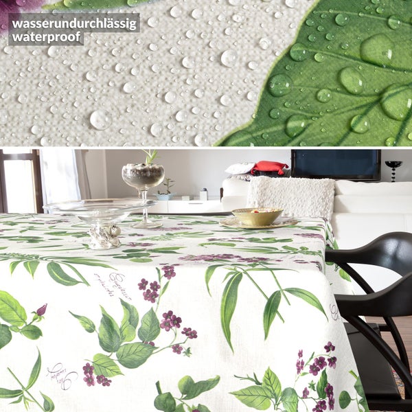 Wasserundurchlässige Tischdecke mit Blumenmuster und Blättern, Detailaufnahme mit Wassertropfen auf der Oberfläche.