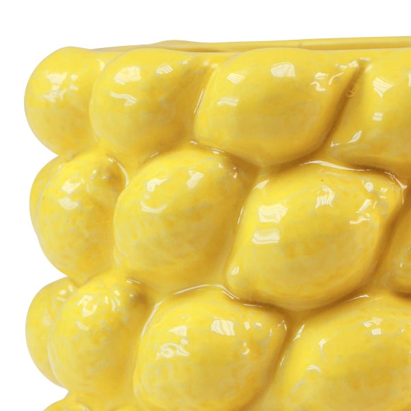 Detailansicht eines gelben Pflanztopfes aus Keramik mit Zitronen-Relief und glänzender Oberfläche.