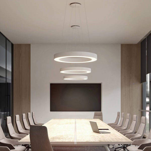 Modernes Konferenzzimmer mit einer LED-Ringpendelleuchte mit drei Ringen über einem Holztisch mit grauen Bürostühlen und einem Laptop.