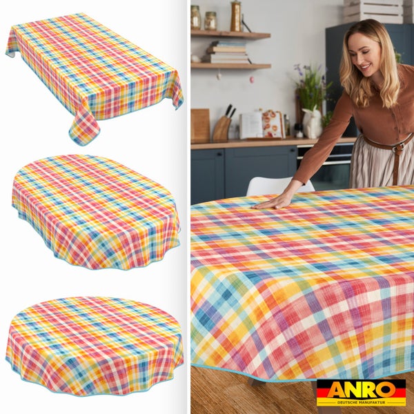 Karierte Tischdecke in rechteckiger, ovaler und runder Form sowie eine Frau, die die Decke in der Küche auflegt. ANRO Deutsche Manufaktur Logo.
