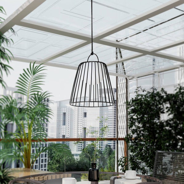 Moderne Pendelleuchte mit schwarzem Metallkäfig und weißer Lichtkugel auf einer hellen Terrasse mit Pflanzen und Stadtblick.
