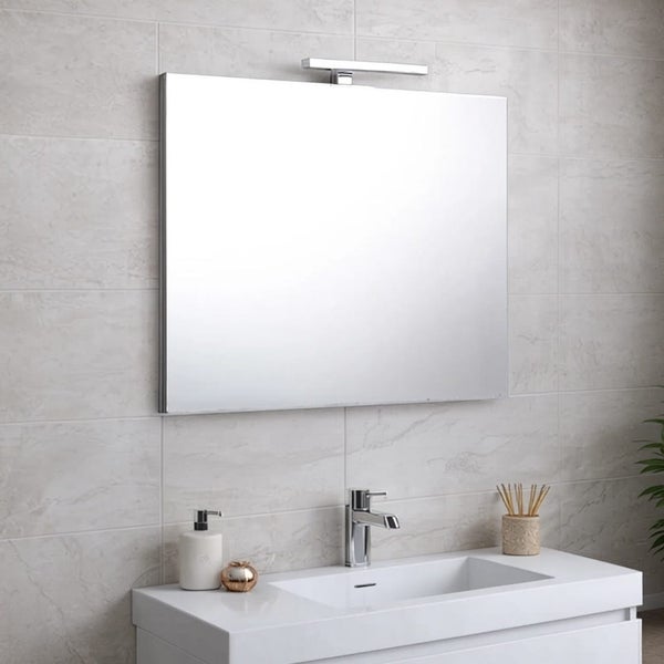 Quadratischer Spiegel mit Beleuchtung über einem Waschbecken im Badezimmer.