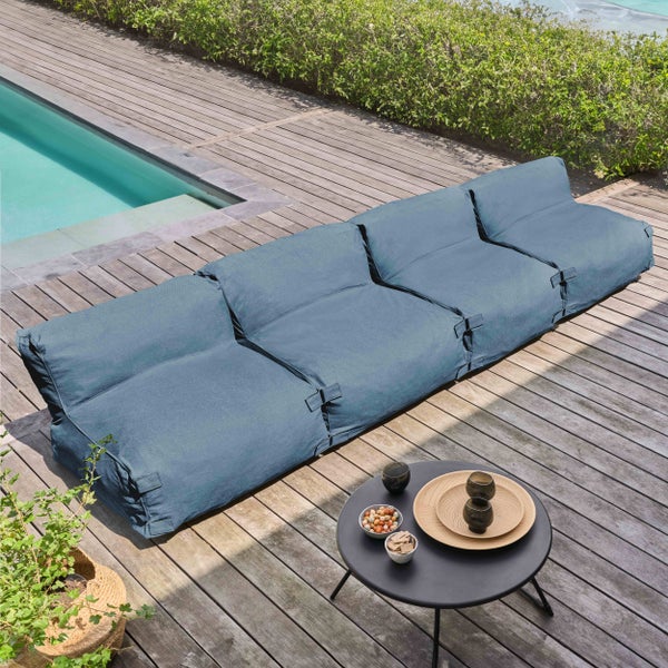 Modulares blaues Outdoor-Lounge-Sofa auf einer Holzterrasse am Pool, moderner Gartenbereich mit Beistelltisch.