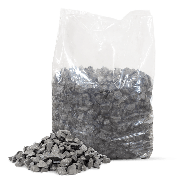 Dunkelgrauer Ziersplitt in einem transparenten Kunststoffsack mit einer kleinen Menge loser Steine davor.