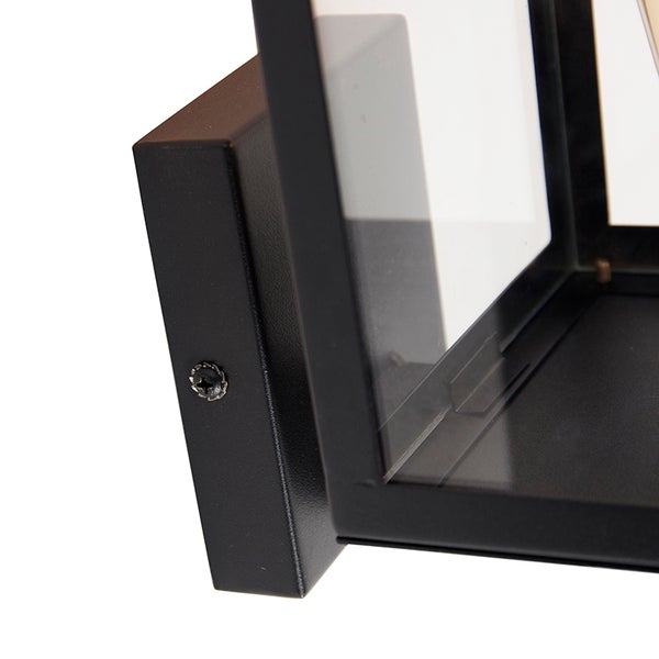 Detailansicht der Wandhalterung einer schwarzen Außenwandleuchte aus Metall und Glas.